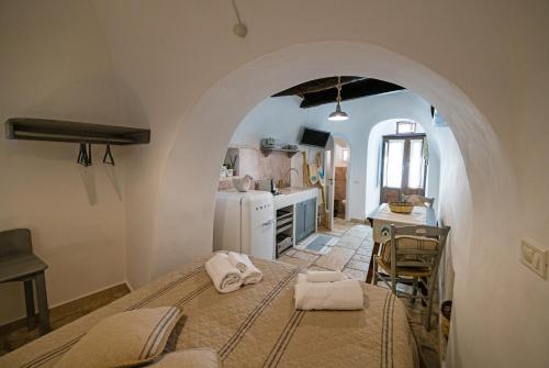 a room with a bed in a kitchen with an archway at Trullo 11 in Alberobello