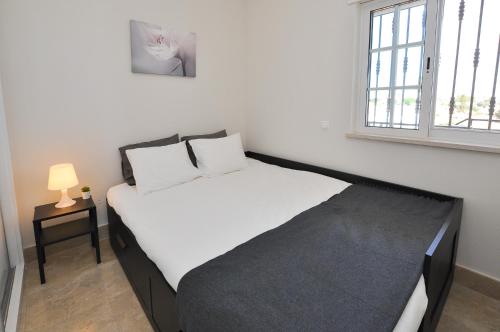 a bedroom with a white bed with a window at Oura Sea View by OCvillas in Albufeira