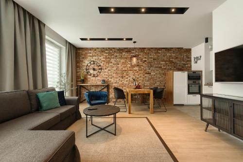 a living room with a couch and a table at Zentrum Apartament IMPERO z Parkingiem in Poznań