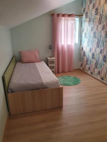 una camera con letto e struttura in legno di Alojamento Local - Casa Amarela ad Alvaiázere