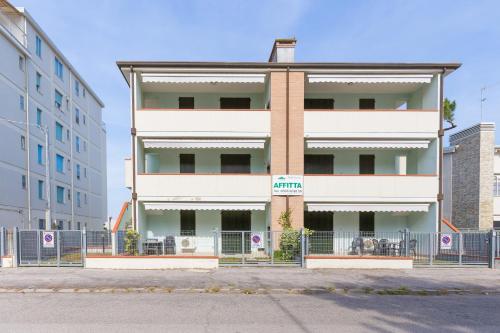 a tall white building with a fence in front of it at SMITH 2A in Lido degli Estensi