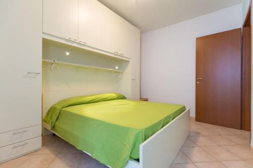 a bedroom with a bed with a green blanket at SMITH 2A in Lido degli Estensi