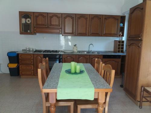 a kitchen with wooden cabinets and a table with candles on it at Casa Fronte Gole Alcantara in Motta Camastra