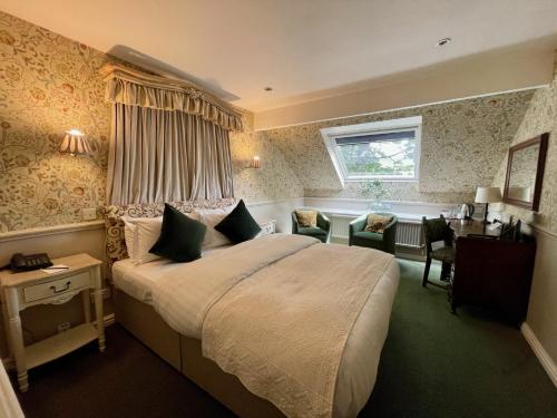 a bedroom with a bed and a desk and a window at Holdsworth House Hotel in Halifax