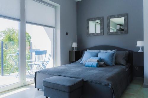 una camera con un letto blu e una sedia di Apartament dla Ciebie a Ustronie Morskie