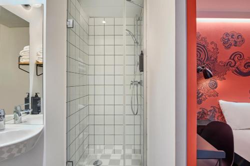 a bathroom with a shower and a sink at Ibis Styles Paris Gare de l'Est Magenta in Paris