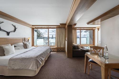 a hotel room with a large bed and a desk at Hotel Annapurna in Courchevel