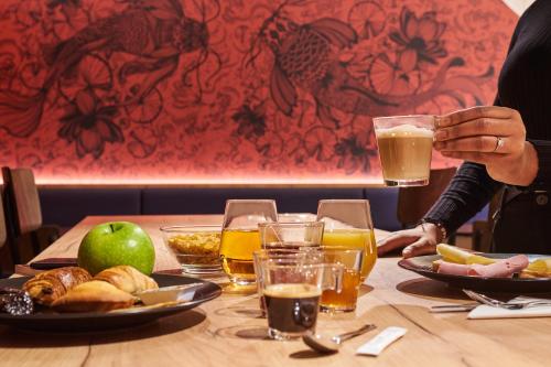 a table with a plate of food and glasses of beer at Ibis Styles Paris Gare de l'Est Magenta in Paris
