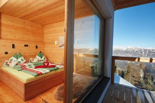 Un dormitorio con una cama en una habitación con ventana. en Krummholzhütte, en Haus im Ennstal