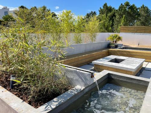 einen Garten mit einem Teich und einem Brunnen in der Unterkunft Cairnvillas: Villa Terra C39 - Luxury Villa with Private Swimming Pool near Beach in Aljezur