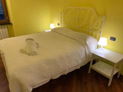 a bed with a white blanket and two night stands at Casa Entella by Vacanze in Chiavari in Chiavari