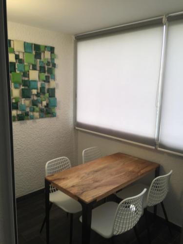 une salle de conférence avec une table et des chaises en bois dans l'établissement Appartement très proche naturiste, chic, piscine, au Cap d'Agde