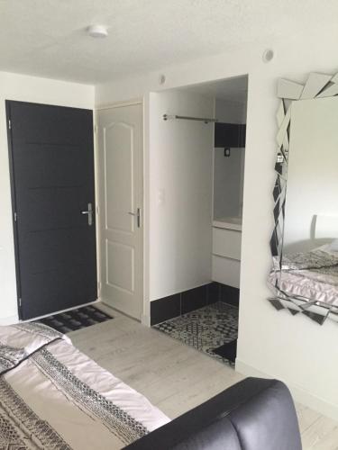 une chambre avec un lit et un miroir dans l'établissement Appartement très proche naturiste, chic, piscine, au Cap d'Agde