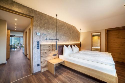 1 dormitorio con 1 cama grande y pared de madera en Ferienwohnung Zypresse en Merano