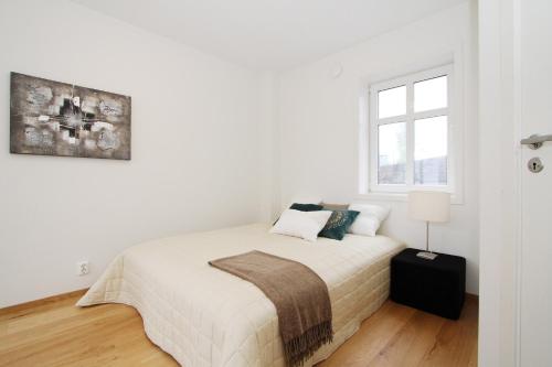 a white bedroom with a bed and a window at Villa Skansen in Bergen