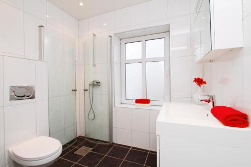 ein weißes Bad mit einem WC und einem Waschbecken in der Unterkunft Villa Skansen in Bergen