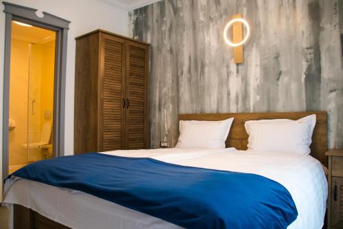 a bedroom with a large bed with a blue blanket at HOTEL ANGEL SOFIA in Fălticeni
