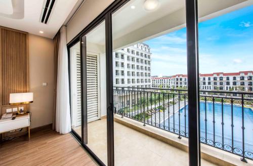 a room with a balcony with a view of the ocean at Vinholidays Fiesta Phu Quoc in Phu Quoc