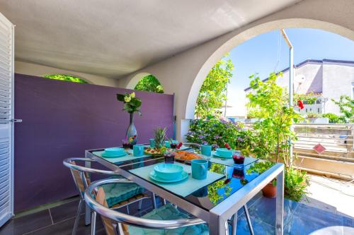 a table with blue dishes on it on a balcony at Apartments Jelena, Mali Lošinj in Mali Lošinj