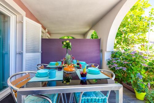 a table with blue dishes on it on a patio at Apartments Jelena, Mali Lošinj in Mali Lošinj