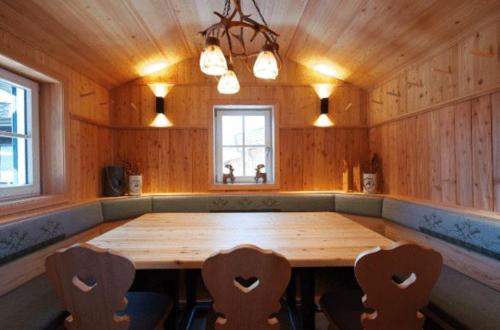 einen großen Holztisch in einem Zimmer mit Stühlen in der Unterkunft Krummholzhütte in Haus im Ennstal