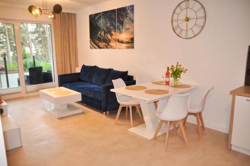 salon ze stołem i niebieską kanapą w obiekcie Apartament Dorado w mieście Mielno