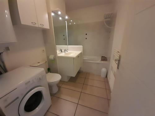 une salle de bain avec toilettes et lavabo et une machine à laver dans l'établissement Magnifique T2 au cœur d'un joli village de vacance Sierra. N 244, à Canet