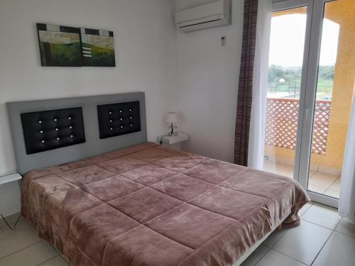 une chambre avec un lit et une grande fenêtre dans l'établissement Magnifique T2 au cœur d'un joli village de vacance Sierra. N 244, à Canet