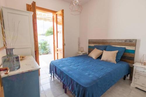 a bedroom with a bed with a blue comforter at Villa Paola by Le Dimore di Paola - Salento in Torre dell'Orso