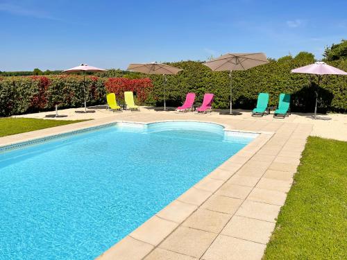 - une piscine avec des chaises et des parasols colorés dans l'établissement La Vieille Fromagerie, à Brux