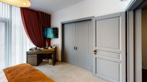 a bedroom with a door and a desk and a table at HOTEL ANGEL SOFIA in Fălticeni