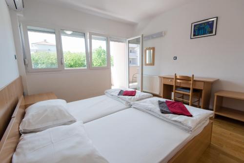 two beds in a room with two windows at Erks Premantura in Premantura