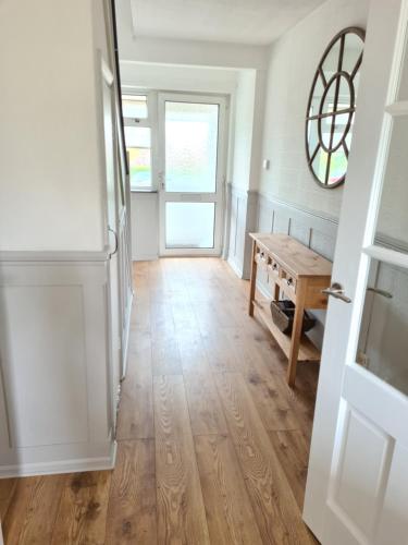 a hallway with a door and a wooden floor at Beach Chalet, Little Walsingham Norfolk in Little Walsingham