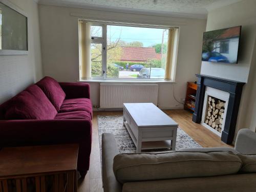 a living room with a couch and a fire place at Beach Chalet, Little Walsingham Norfolk in Little Walsingham