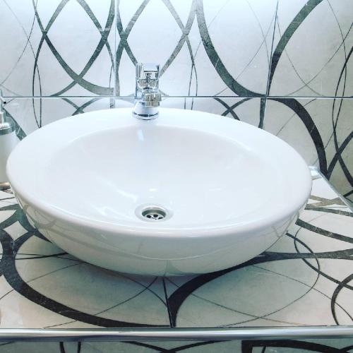 a white sink sitting on a counter in a bathroom at 3 Goddesses' studios in Koukounaries