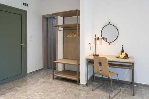 a desk and a chair in a room with a door at 3 Goddesses' studios in Koukounaries