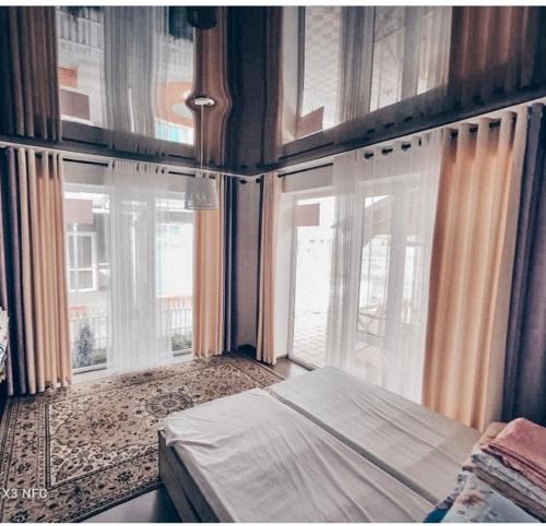 a bedroom with a bed and two windows at Коттедж в ЦО Париж in Chok-Tal