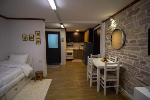 a bedroom with a bed and a table and chairs at Solhouse in Gjirokastër