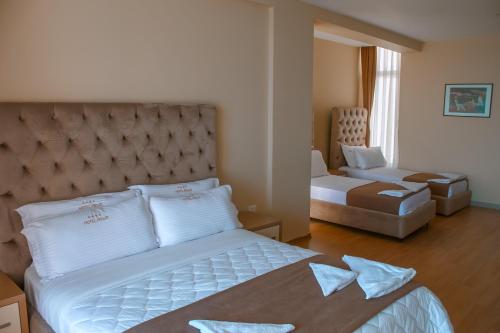 Un pat sau paturi într-o cameră la Hotel Frojd - Beach Front Resort