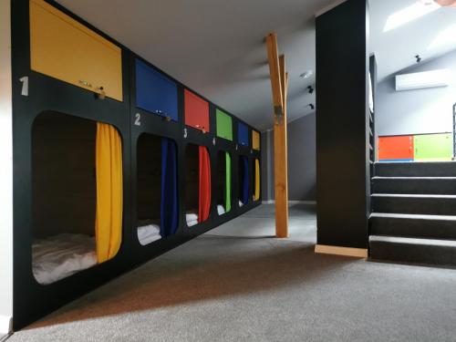Kapsuła Hostel في زاتور: غرفة مع سرير بطابقين مع جدران ملونة