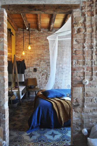 a bedroom with a bed in a brick wall at Maison du Flâneur in Chioggia