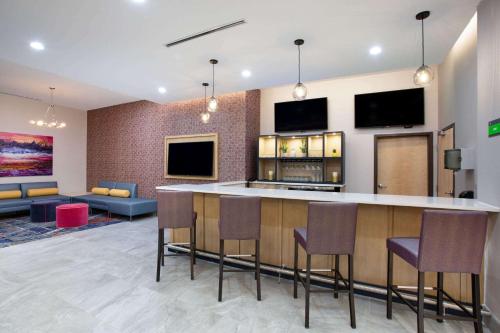 a lobby with a bar with chairs and a living room at La Quinta Inn & Suites by Wyndham Manassas, VA- Dulles Airport in Manassas