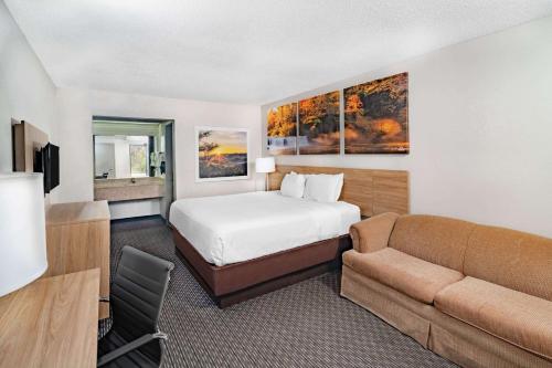 una habitación de hotel con una cama y un sofá en Days Inn by Wyndham Cookeville, en Cookeville