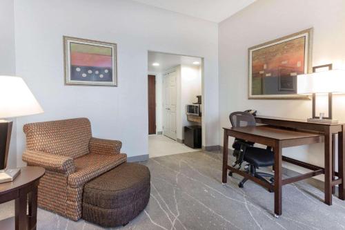 a hotel room with a desk and a chair and a desk at Wingate by Wyndham Tinley Park in Tinley Park