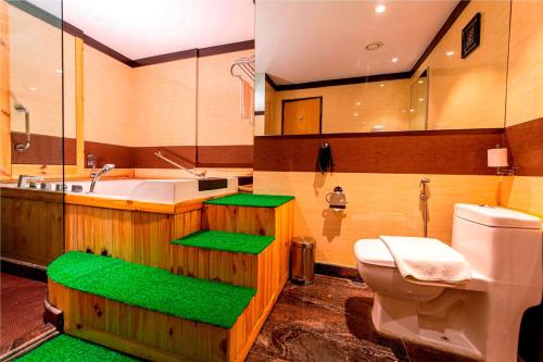 a bathroom with a toilet and a sink and a tub at Ramada Neemrana in Neemrana