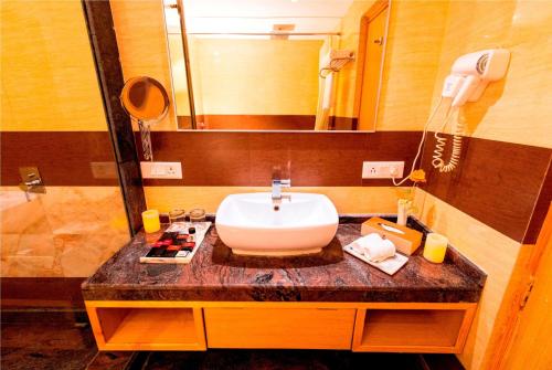 a bathroom with a sink and a mirror at Ramada Neemrana in Neemrana