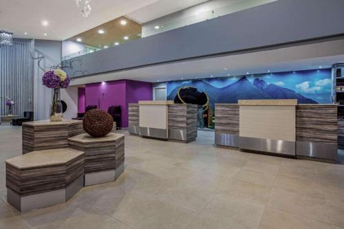 a lobby of a store with purple walls and furniture at CHN Hotel Monterrey Centro, Trademark Collection by Wyndham in Monterrey