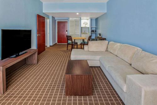 a living room with a couch and a flat screen tv at CHN Hotel Monterrey Centro, Trademark Collection by Wyndham in Monterrey