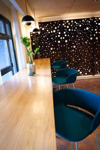 a conference room with a wooden table and blue chairs at Mercure Perpignan Centre in Perpignan