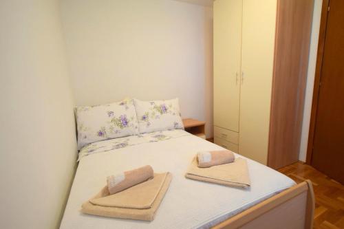 - une petite chambre avec un lit et 2 serviettes dans l'établissement Apartment Mirela, à Malinska
